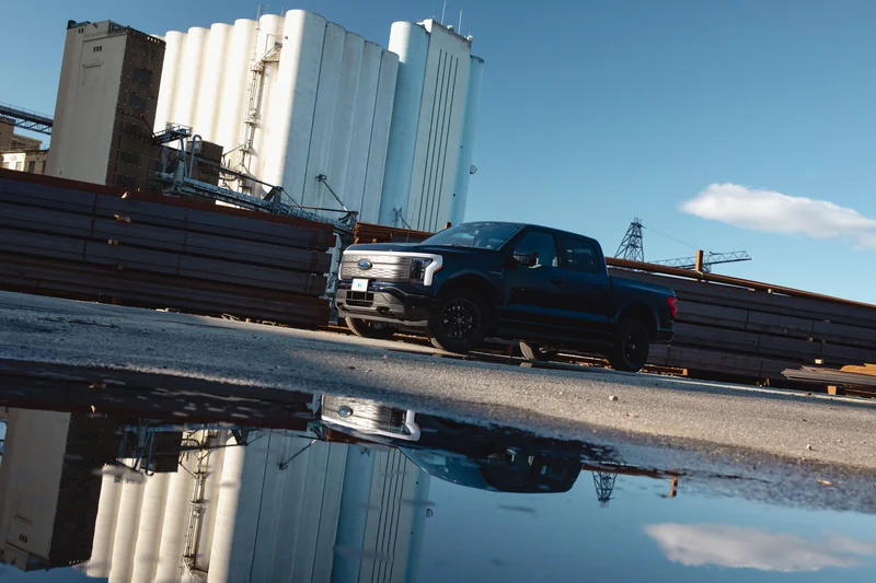 Pickup speilet i en vannpytt på industriområde