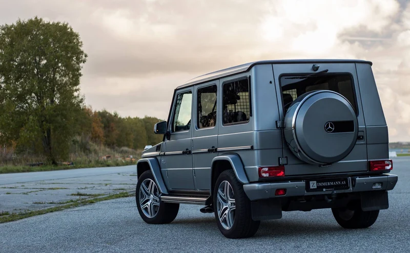 Sølvgrå Mercedes-Benz G-klasse fotografert bakfra utendørs