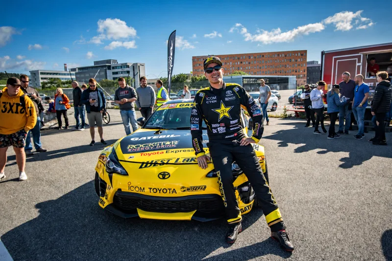 Fører foran gul Toyota driftbil under et bilarrangement