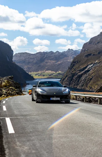 Mørk Ferrari GTC4Lusso i fart på fjellvei