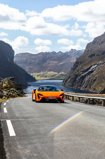 Oransje McLaren Artura i fart på fjellvei
